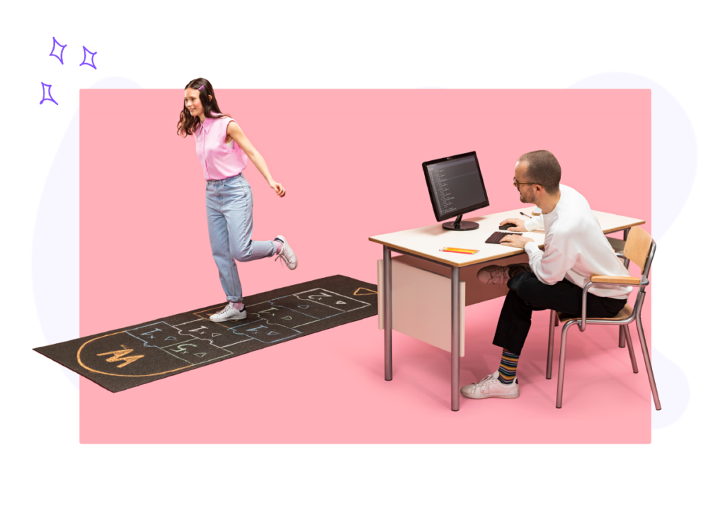 Una studentessa che gioca a Campana allegramente mentre un docente la guarda incoraggiante dietro una scrivania e scrive al computer